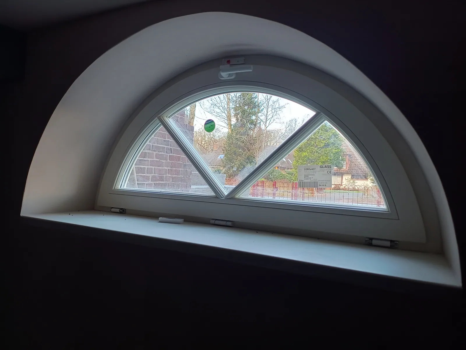 Rundbogenfenster mit Sprossen im Dachgeschoss