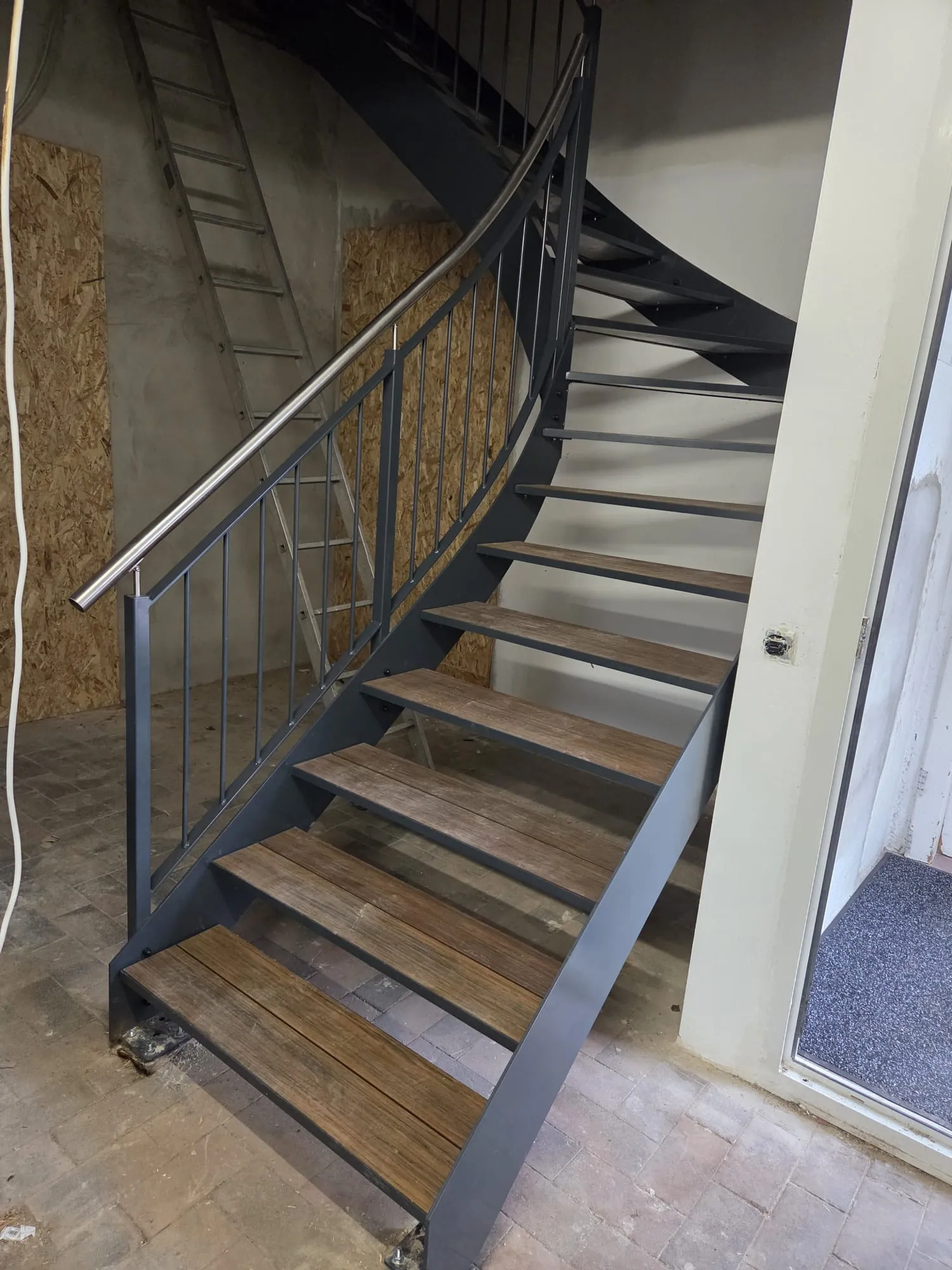 Stahltreppe mit Holzstufen und Edelstahlgeländer im Innenbereich